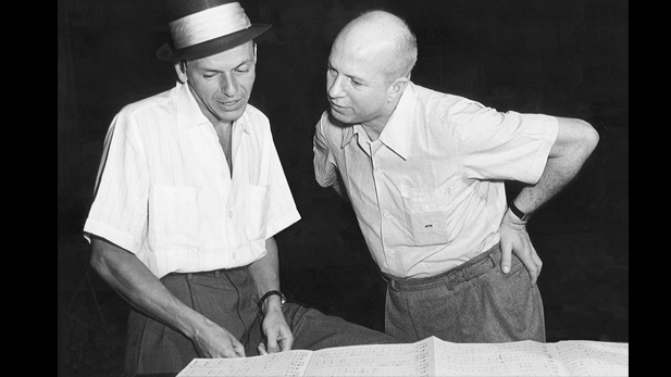Frank Sinatra (left) and Jimmy Van Heusen looking at music together, 1950s.