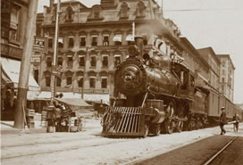 sepia photo of train through city