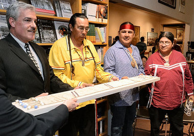 Gregg Tripoli (left), executive director of the Onondaga Historical Association, returns a wampum belt that has been in the museum's possession back to Tadodaho Sid Hill, Chief Jake Edwards, and Faithkeeper Tony Gonyea, of the Onondaga Nation during a news conference at the museum. Photo Credit: Peter Chen / The Post-Standard
